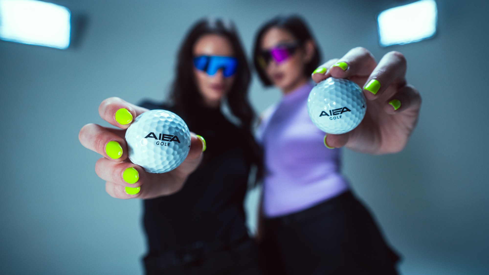 Electric Lime nails holding AIEA golf balls